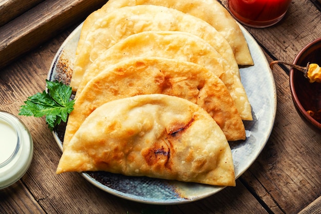 Chebureks, torte fritte a forma di mezzaluna con ripieno di carne. Torte fritte