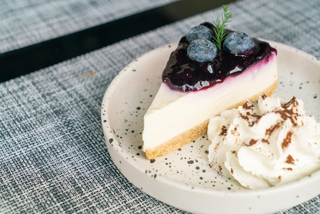 cheese cake ai mirtilli con panna montata sul piatto