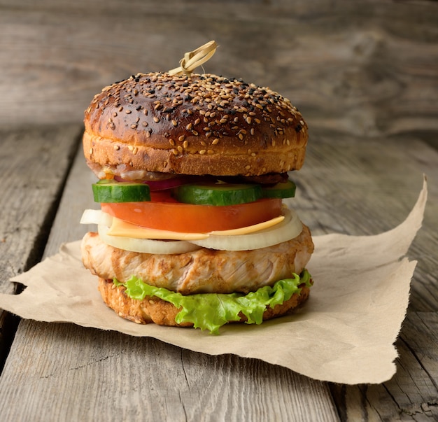 Cheeseberger con panino, carne e verdure su un tavolo di legno, fast food