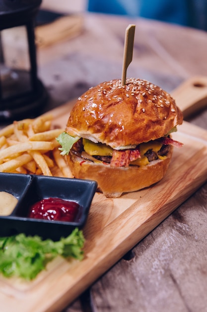 Cheeseburger di manzo servito con patatine fritte