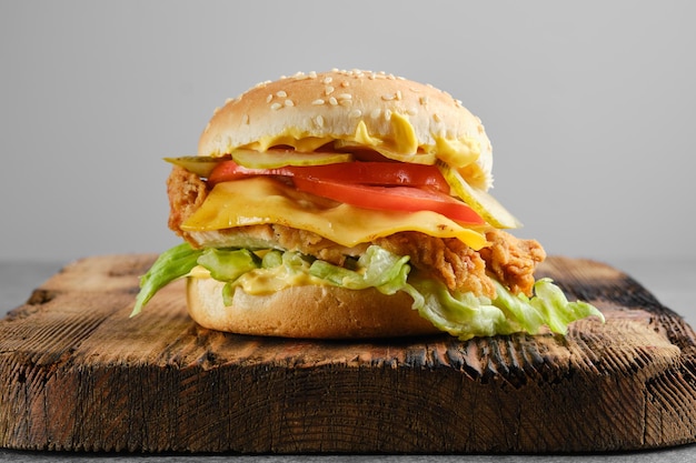 Cheeseburger di pollo con verdure fresche e marinate sulla vista frontale del fondo di legno