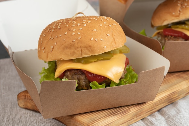 Cheeseburger in imballaggi di carta per una consegna