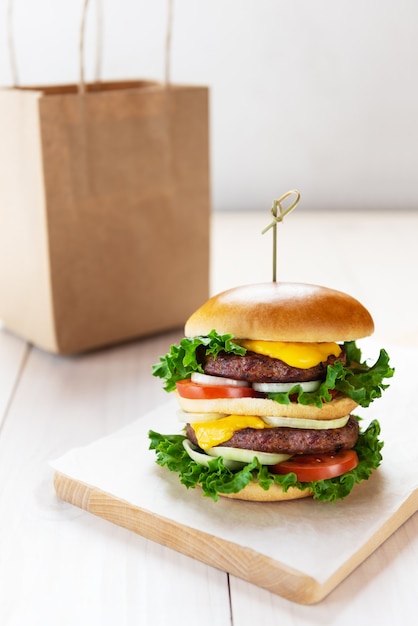 Cheeseburger vegetariano su un tavolo di legno bianco consegna cibo