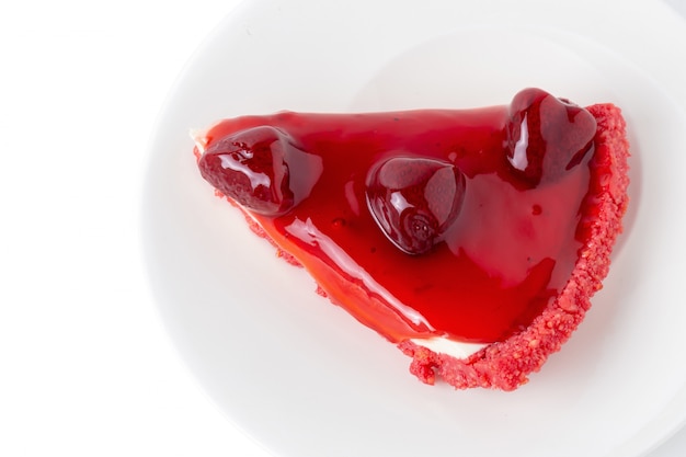 Cheesecake alla fragola sopra un piatto bianco isolato su sfondo bianco