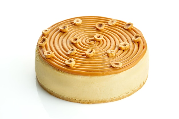 Cheesecake con caramello e noci su sfondo bianco