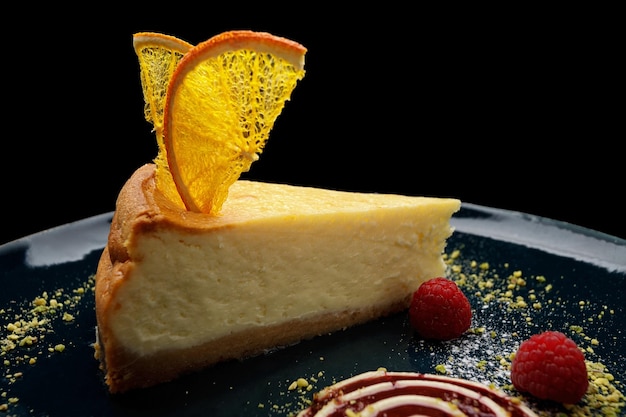 Cheesecake con chips di arancia e lamponi su un piatto