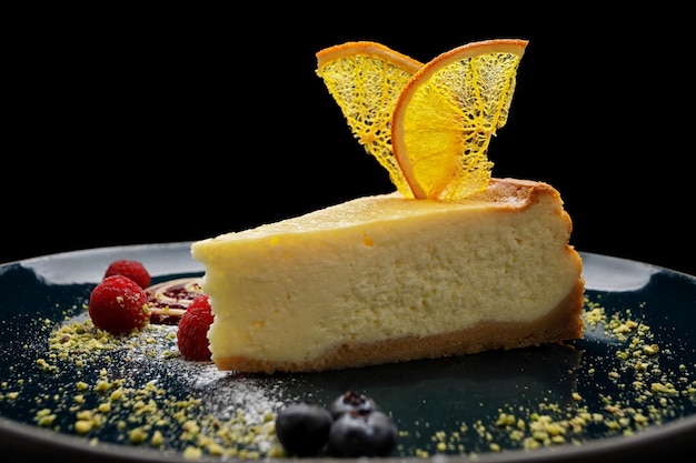 Cheesecake con chips di arancia e lamponi su un piatto