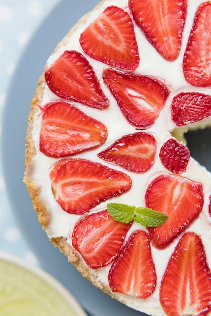 Cheesecake con fragole fresche e menta Gustosa torta con crema bianca a bacca rossa e foglie di menta verde su un piatto