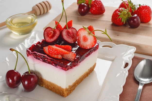 Cheesecake con frutti di bosco, fragola fresca e cheesecake alla ciliegia sul tavolo.