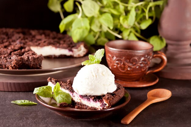 Cheesecake cremoso con cioccolato, ribes nero, gelato e foglie di menta per la decorazione