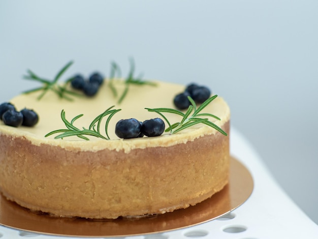 Cheesecake decorata con bacche di mirtillo e rametti di rosmarino