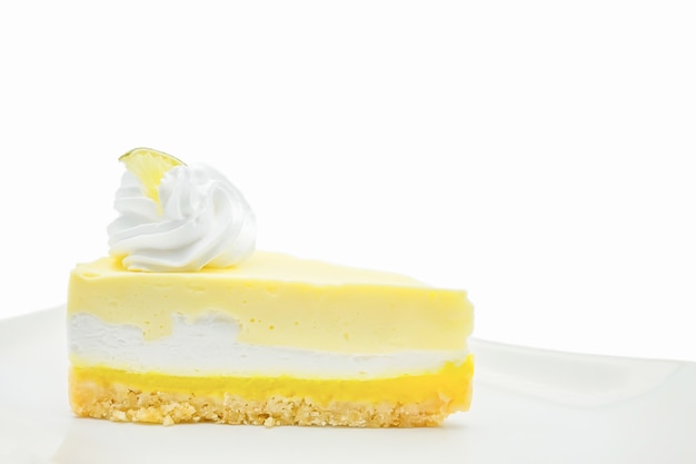 Cheesecake della limetta del limone sull&#39;isolato bianco del piatto su fondo bianco