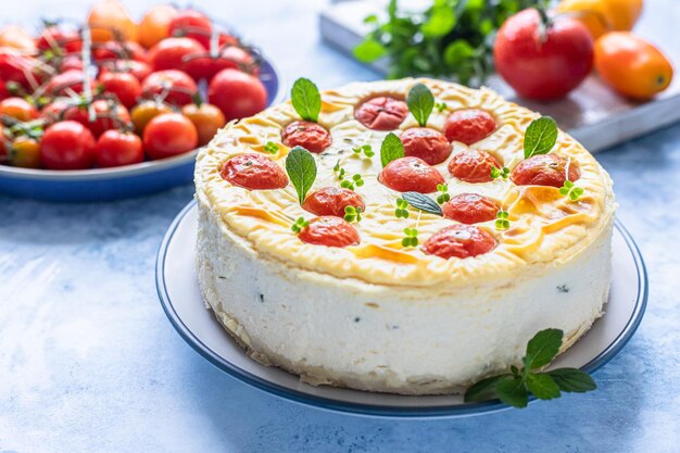 Cheesecake salata con pomodori decorata con fondo cemento blu menta