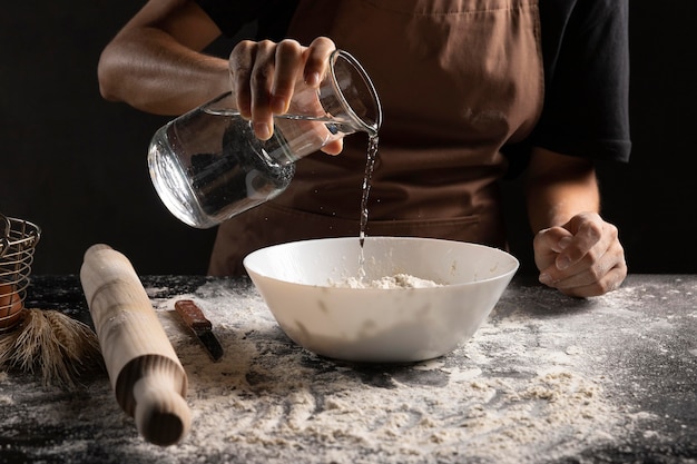 Chef aggiungendo acqua per mescolare per creare la pasta