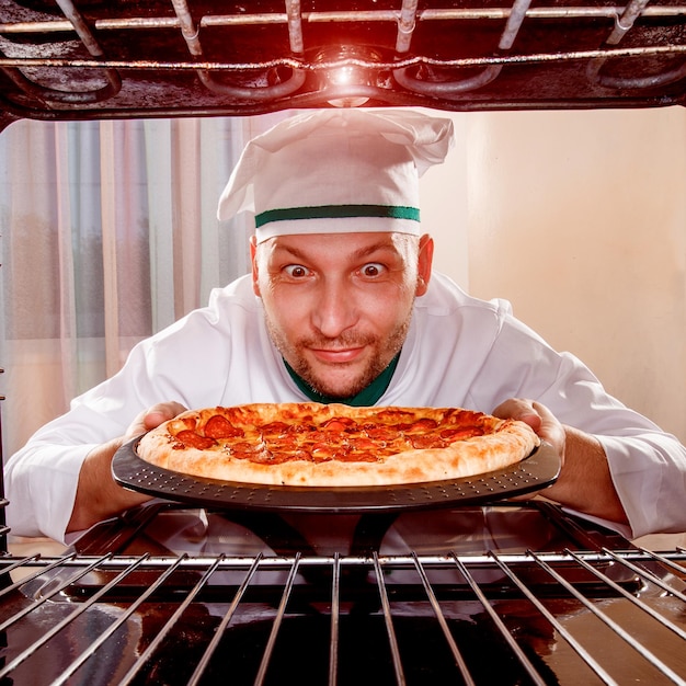 Chef che cucina la pizza al forno.