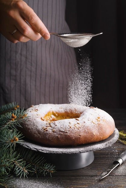 Chef che decora il dessert del giorno dell'epifania con zucchero a velo