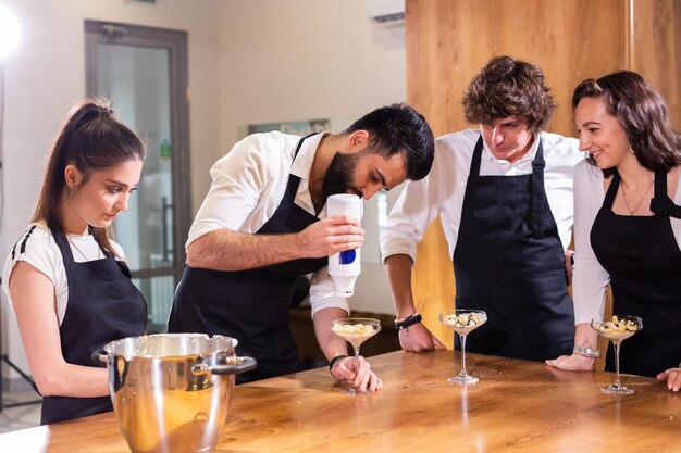 Chef che insegna ai tirocinanti come preparare il gelato cucinando un gustoso dessert gelato a base di cioccolato e