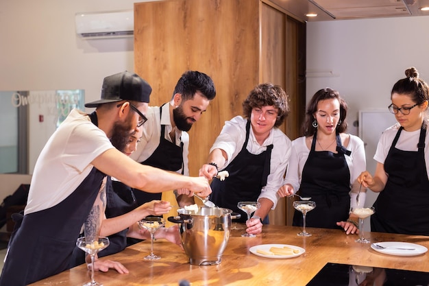 Chef che insegna ai tirocinanti come preparare il gelato cucinando un gustoso dessert gelato a base di cioccolato e