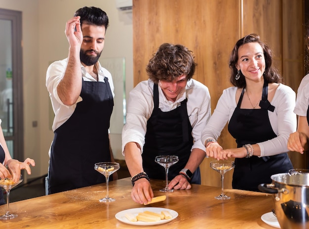 Chef che insegna ai tirocinanti come preparare il gelato cucinando un gustoso dessert gelato a base di cioccolato e