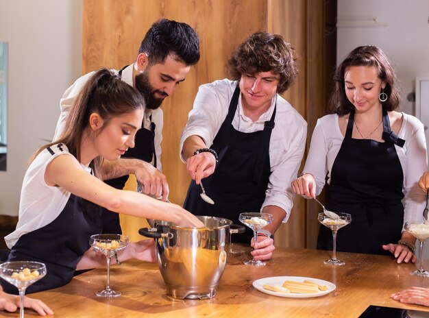 Chef che insegna ai tirocinanti come preparare il gelato cucinando un gustoso dessert gelato a base di cioccolato e