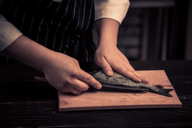 Chef che taglia il pesce su una tavola