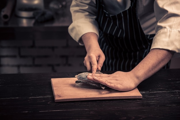 Chef che taglia il pesce su una tavola