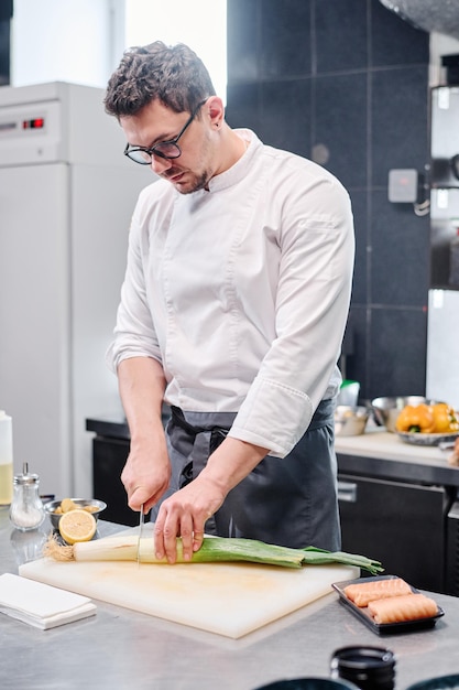 Chef che taglia il sedano per insalata