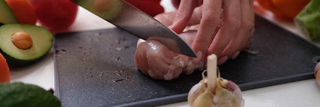 Chef che taglia la carne a bordo vicino al primo piano delle verdure