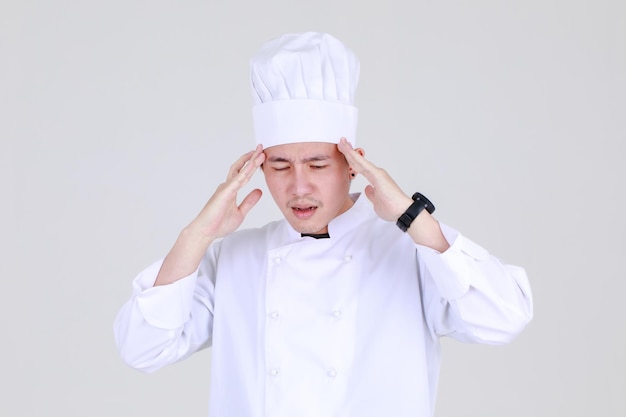 Chef cinese esperto e intelligente su un'elegante uniforme da cucina si sente sconvolto e preoccupato per la salute dei deboli in cucina come esperto qualificato di cucina per cene di lusso