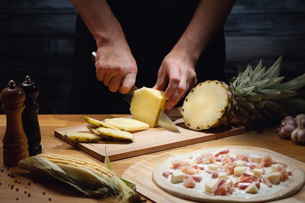 Chef di cucina pizza hawaiana, taglio di ananas fresco