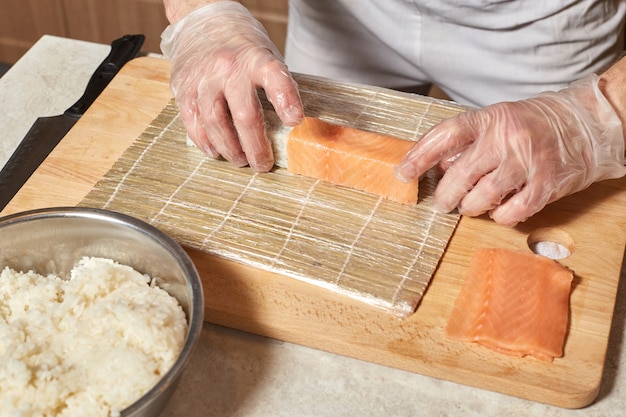 Chef fare sushi. Preparare involtini con salmone