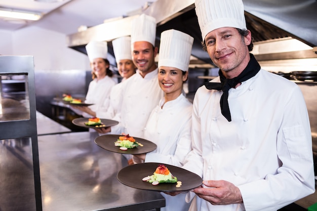 Chef felici che presentano i loro piatti di cibo