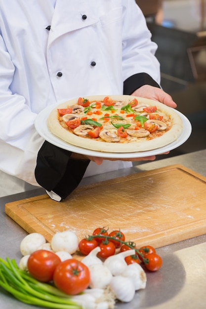 Chef in possesso di pizza ai funghi