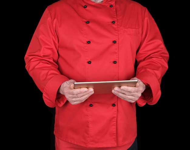 Chef in uniforme rossa in possesso di un tablet elettronico nelle sue mani