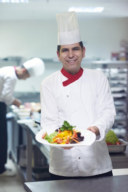 chef nella cucina dell'hotel che prepara e decora il cibo, deliziose verdure e cena a base di carne