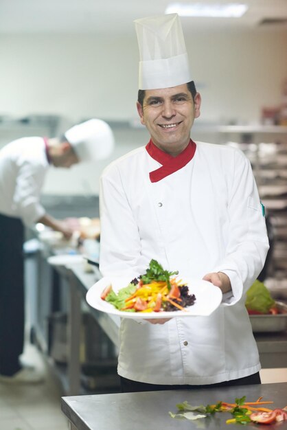 chef nella cucina dell'hotel che prepara e decora il cibo, deliziose verdure e cena a base di carne