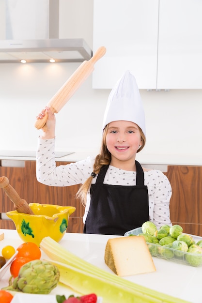 chef ragazza bambino sul controsoffitto gesto divertente con rullo impastare