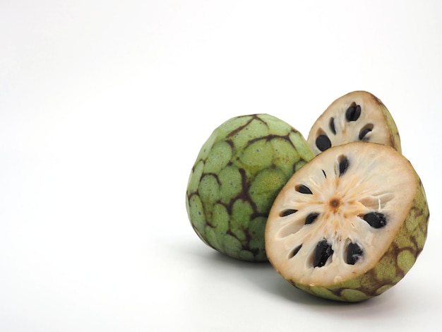 Cherimoya Annona cherimola tagliata a metà e intera isolata su sfondo bianco