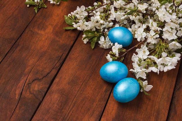 Cherry Blossom Branch ed uova di Pasqua su un fondo di legno.