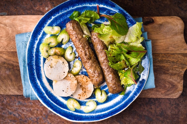 Chevanchichi con lattuga e daikon su un piatto blu