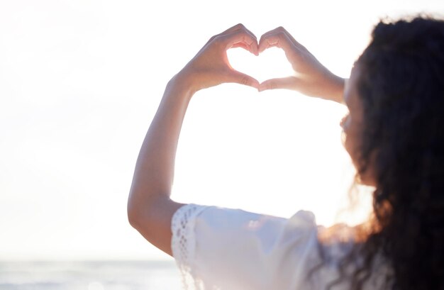 Chi non ama l'estate Scatto di una persona irriconoscibile che fa un gesto del cuore con le mani in spiaggia