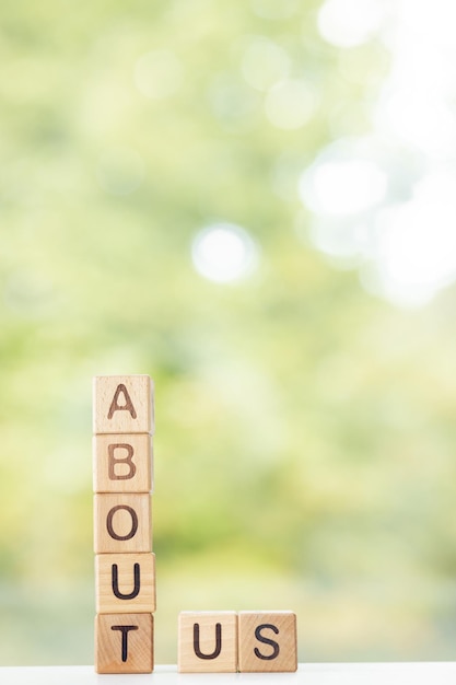 Chi siamo è scritto su cubi di legno su uno sfondo verde estivo Primo piano di elementi in legno