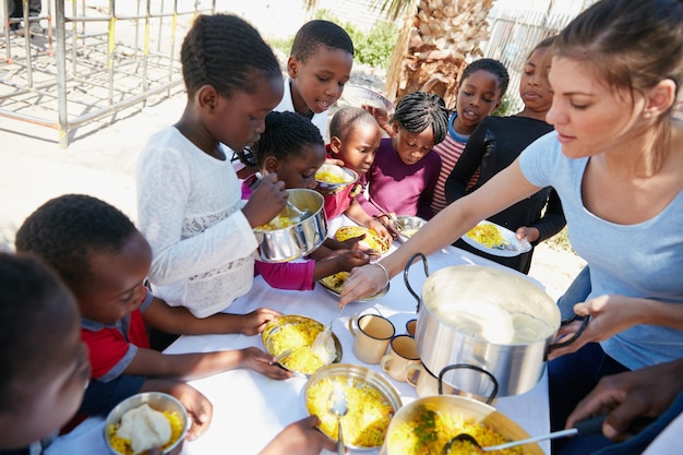 Chi vuole la salsa Foto ritagliata di bambini che vengono nutriti in un ambulatorio di cibo