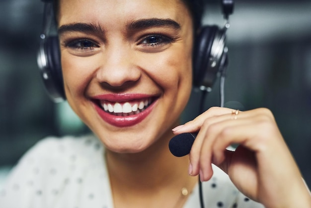 Chiamaci per un'assistenza clienti di qualità quando ne hai bisogno Ritratto di un giovane agente di call center che lavora fino a tardi in un ufficio