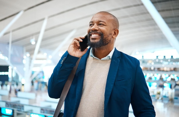 Chiamata di lavoro e aeroporto uomo di colore con un sorriso pronto per il viaggio in aereo e il lavoro globale Felicità della connessione mobile e uomo d'affari con bagagli per aereo e networking esecutivo sul cellulare