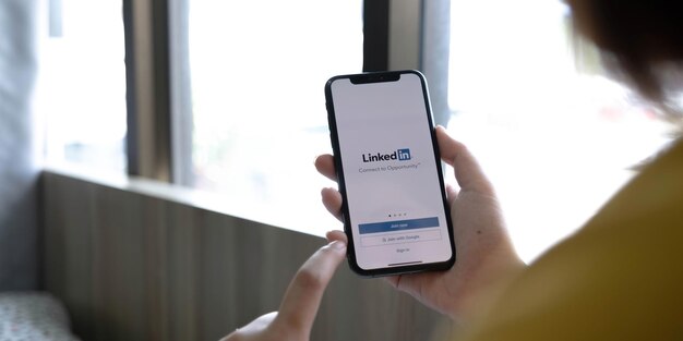 CHIANG MAI THAILANDIA 12 LUGLIO 2022 Una donna tiene Apple iPhone Xs con l'applicazione LinkedIn sullo schermoLinkedIn è un'app di condivisione di foto per smartphone