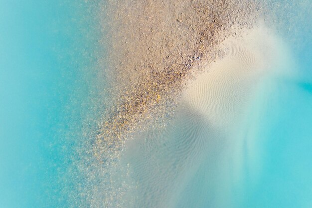 Chiare acque azzurre in un lago di montagna La riva con le pietre Vista dell'acqua da un drone Paesaggio dall'aria Paesaggio naturale come sfondo Laghi di montagna dell'Alberta Canada