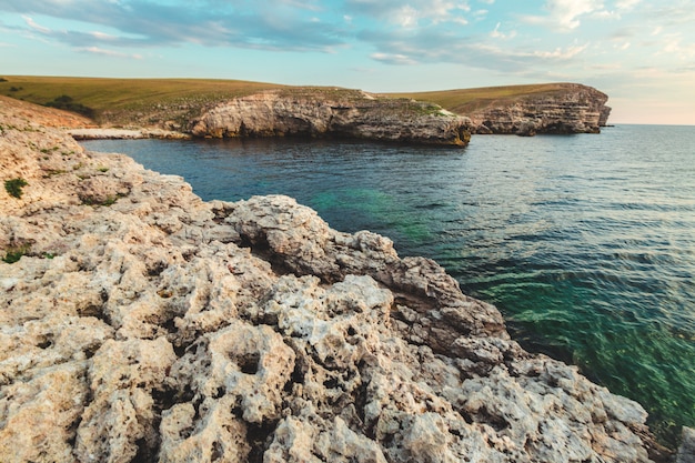 Chiaro cielo sopra un mare blu dalla spiaggia Scogliere sullo sfondo