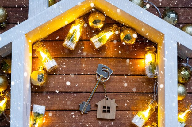 Chiave della casa con un portachiavi piccola casa su sfondo di legno con layout di decorazione di Natale