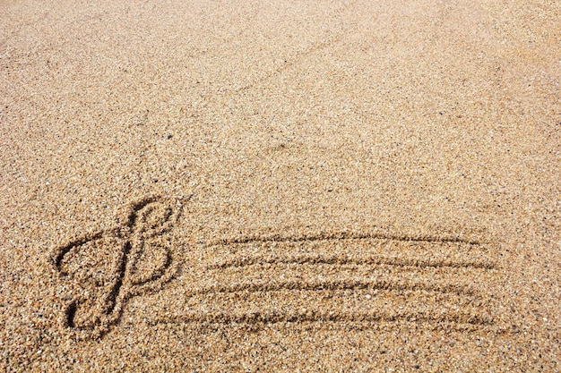 Chiave di violino disegnata sulla sabbia in riva al mare